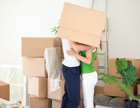 Removals team loading moving boxes into a van